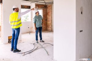 Construction engineer discussing with architect worker at indoor building site